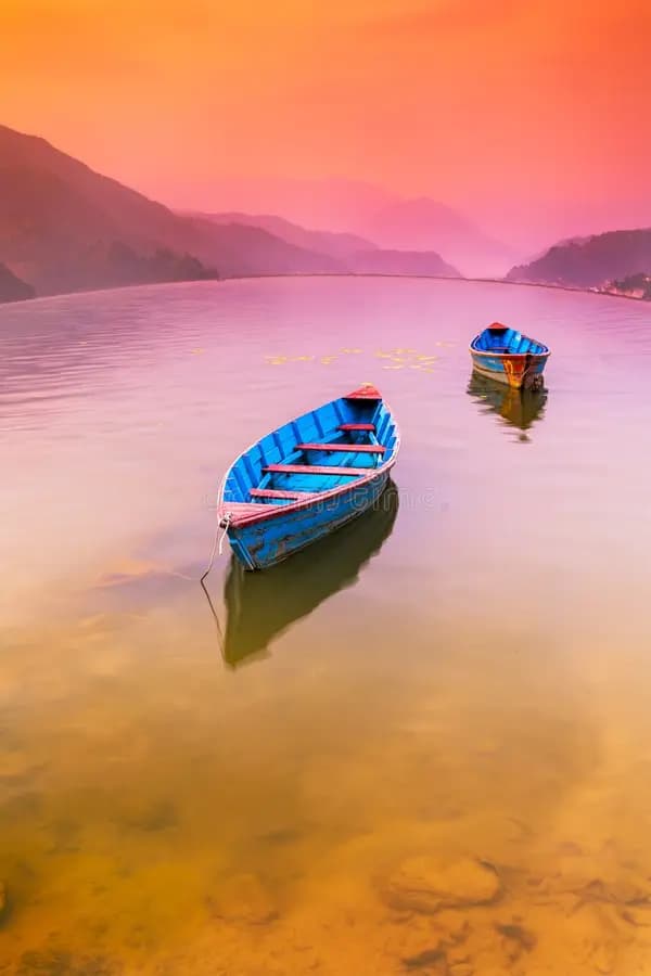 Wooden boats on Phewa Lake at sunset